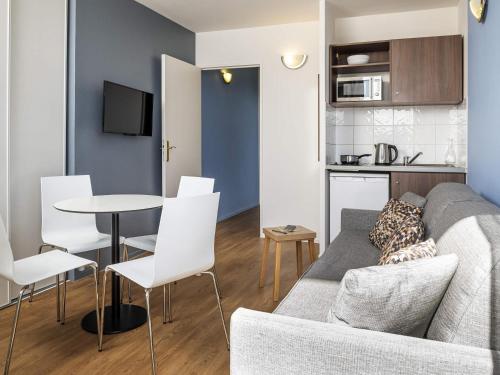 a living room with a couch and a table at Aparthotel Adagio Access Paris Quai d'Ivry in Ivry-sur-Seine