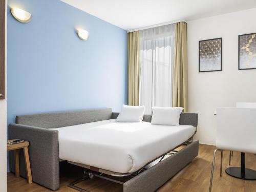 a bedroom with a large white bed in a room at Aparthotel Adagio Access Paris Quai d'Ivry in Ivry-sur-Seine