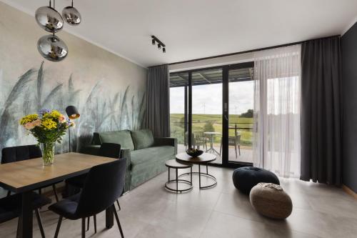 a living room with a green couch and a table at Port Rybaki & Vine Agritourism in Brodnica