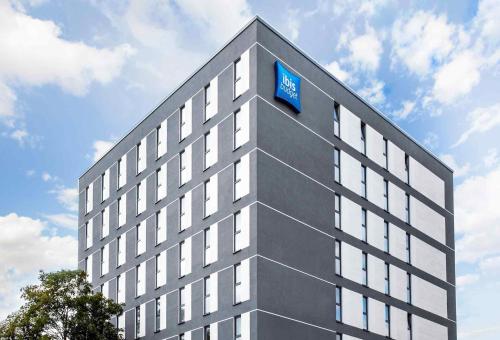 a building with a blue sign on the top of it at Ibis budget Osnabrück City in Osnabrück