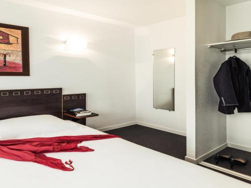 a bedroom with a white bed and a mirror at Aparthotel Adagio Access Toulouse Jolimont in Toulouse