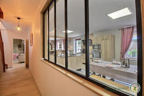 a room with a large glass window in a kitchen at Maison de la ville-j in Plénée-Jugon