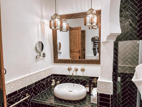 a bathroom with a sink and a mirror at Riad NL&S Collection in Marrakech