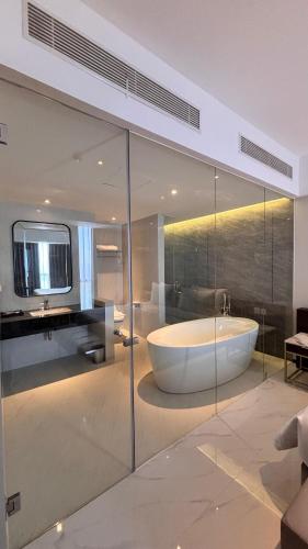a large bathroom with a tub and a sink at Grand Whiz Hotel Praxis Surabaya in Surabaya