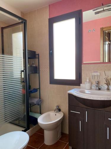 a bathroom with a toilet and a sink and a mirror at El rincón de Bonilla in El Ronquillo