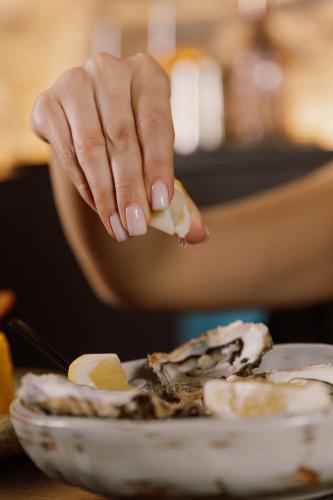 a hand holding a piece of food next to a plate of food at Pullman Riga Old Town in Rīga