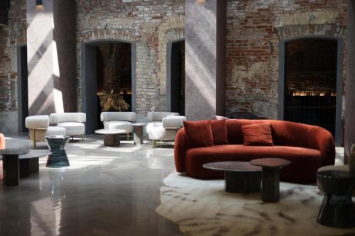 a living room with a red couch and tables at Pullman Riga Old Town in Rīga