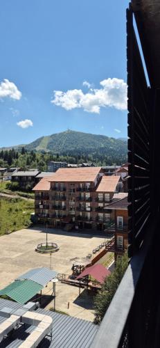 a view of a building with a parking lot at Bakuriani Mgzavrebi Block 9 Apartments in Bakuriani