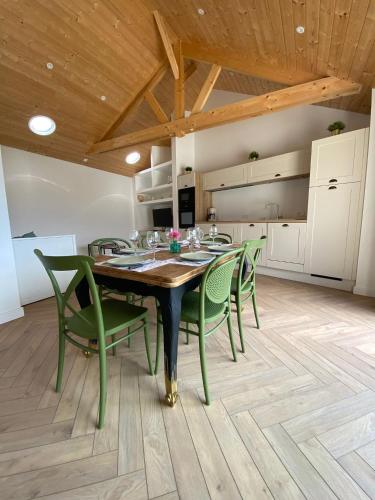Un comedor con una mesa y sillas verdes. en L'Escale, en Cancale