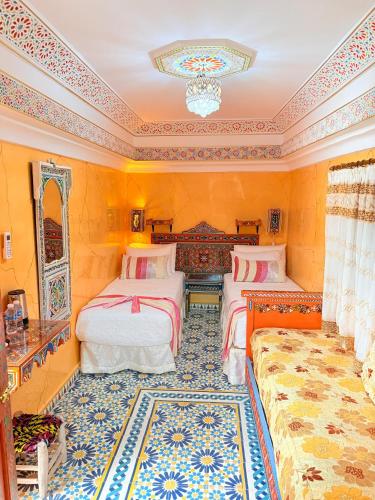 a bedroom with two beds and a rug at Riad Las mil y una noches 2 Tetuan in Tetouan