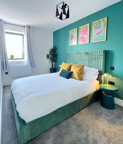 a bedroom with a large bed with blue walls at Luxury Norwich City Centre Apartment - Free Parking in Norwich