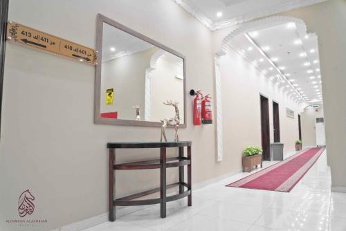 a hallway with a mirror and a table on a wall at SAHARI ALFORSAN HOTEL Sabya فندق صحاري الفرسان in Şabyā