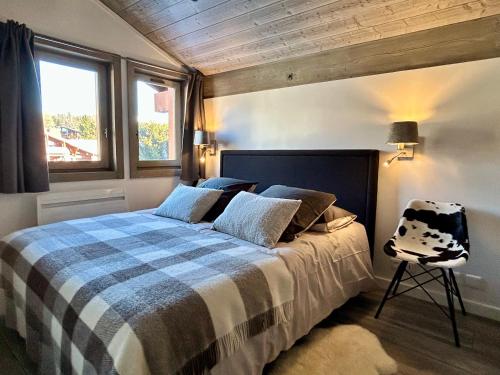 a bedroom with a bed and a chair in it at Séjour lumineux avec vue sur les cimes in Megève