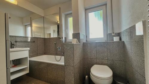 a bathroom with a toilet and a tub and a sink at Wohnung 1 Altstadt in Ulm