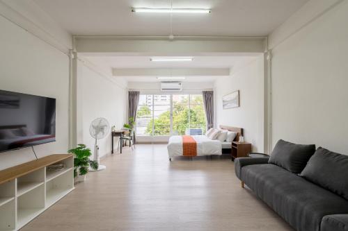a living room with a couch and a bed at Glow House Sukhumvit 54 in Bangkok