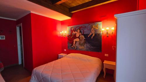 a red bedroom with a bed and a painting on the wall at Perbacco in SantʼAngelo Limosano