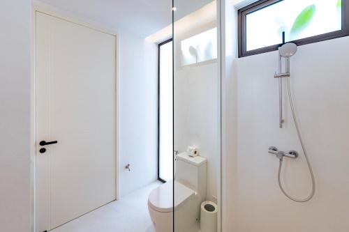 a white bathroom with a toilet and a shower at Anzhu Seamate Villa Samui in Amphoe Koh Samui