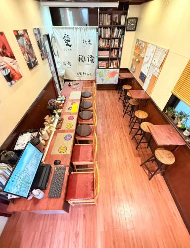 a room with a long table with books and chairs at KOBE coffee hostel in Kobe