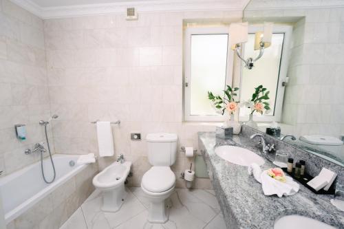 a bathroom with a toilet and a sink and a tub at Villa Bellevue Portoroz-Portorose in Portorož
