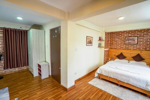 パタンにあるHariman Chhen Homestay Aのレンガの壁とベッドが備わるベッドルーム1室が備わります。