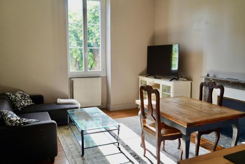 a living room with a table and a tv at Appartement Nr 1 Centre Ville 2 personnes 50m2 rénové in Tarbes
