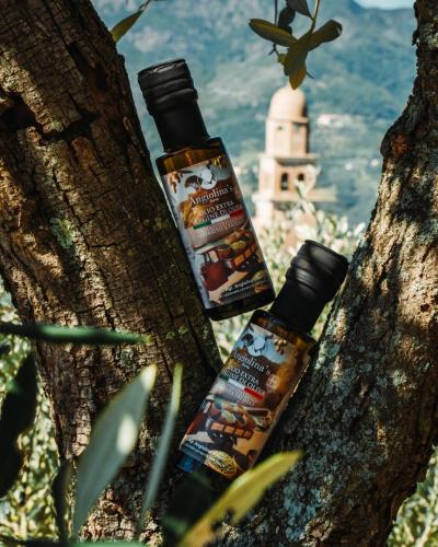 a bottle of essential oils sitting on a tree at Angiolina's Farm in Levanto