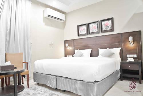a bedroom with a large white bed and a desk at SAHARI ALFORSAN HOTEL Sabya فندق صحاري الفرسان in Şabyā