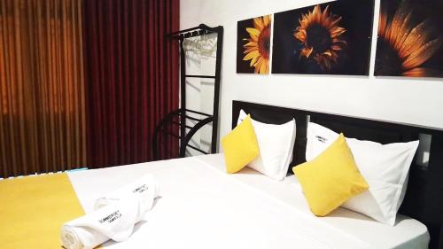 a bedroom with a bed with yellow and white pillows at SummerSet in Dambulla