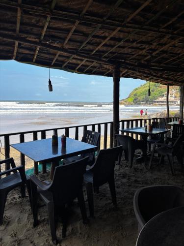 a restaurant on the beach with tables and chairs at Absolute paradise Kudle beach in Gokarna