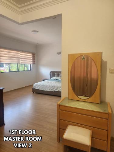 a bedroom with a bed and a dresser with a mirror at B&C Homestay in Miri