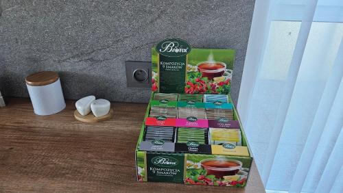 a box of cupcakes and cups of coffee on a table at Jeziorna Green Apartment in Siewierz