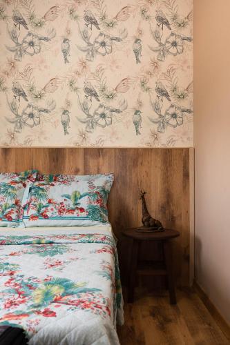 a bedroom with a bed with a floral wallpaper at Apto Aconchegante Na Cidade do Café in Brejetuba