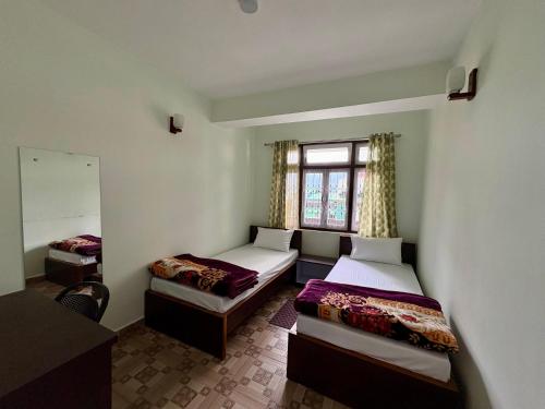 a room with two beds and a window at Lotus Zen Stay in Gangtok