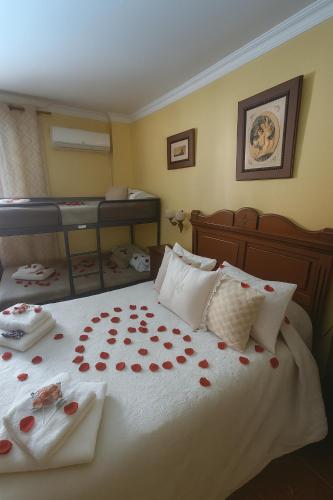 a bedroom with a bed with red roses on it at Casa Rural Chalet Venta del Aire Cortijo Terron in Lanjarón