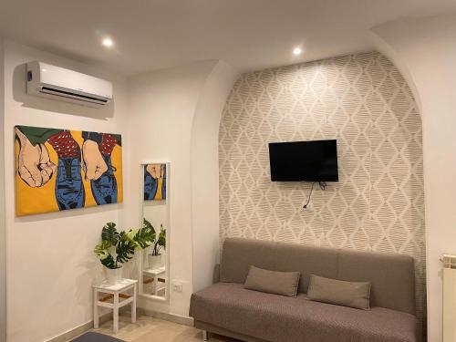 a living room with a couch and a flat screen tv on a wall at THE ROOM 115 in Rome