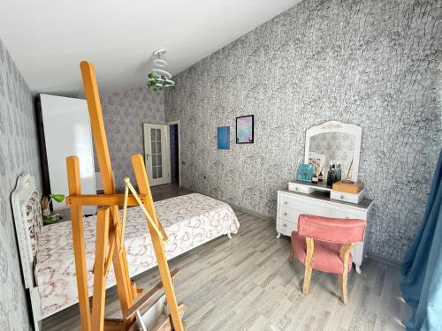 a bedroom with a bed and a desk and a mirror at Villa Della Mardakan in Mardakan