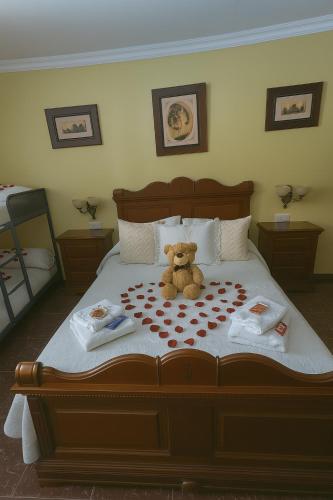 a teddy bear sitting on top of a bed at Casa Rural Chalet Venta del Aire Cortijo Terron in Lanjarón