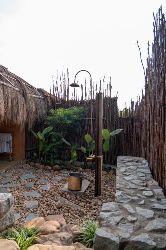 a garden with a stone path and a fence at The Mudhouse Marayoor in Munnar