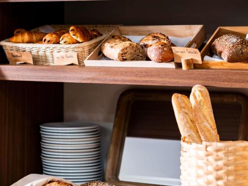 two shelves with different types of breads and baskets at ibis Styles Quiberon Centre in Quiberon