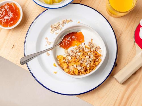 a bowl of granola and honey on a plate at ibis budget Zurich Airport in Glattbrugg
