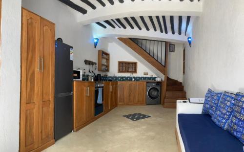 a kitchen with wooden cabinets and a washer and dryer at Dhow House in Bagamoyo