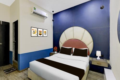 a bedroom with a large bed with a blue wall at Hotel O The Superior in Bhatha