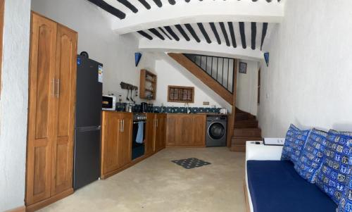 a kitchen with wooden cabinets and a blue couch at Dhow House in Bagamoyo