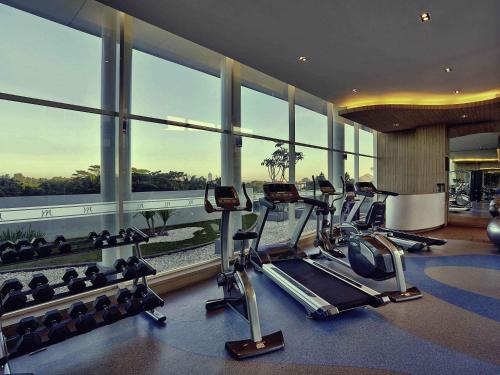 a gym with cardio equipment in a building with windows at Mercure Serpong Alam Sutera in Serpong