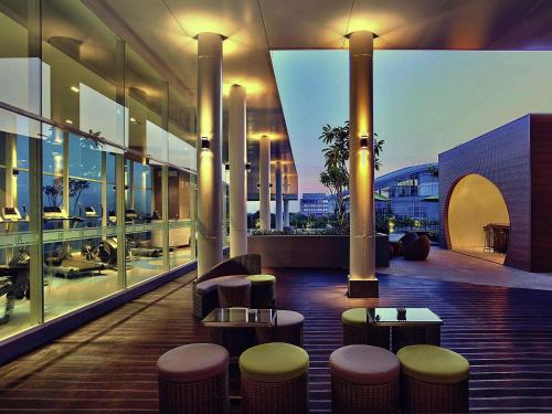 a lobby with stools and tables on a building at Mercure Serpong Alam Sutera in Serpong