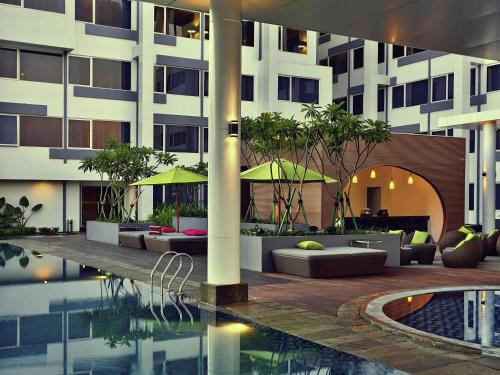 a hotel courtyard with a pool and a building at Mercure Serpong Alam Sutera in Serpong