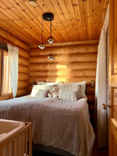 a bedroom with a bed in a log cabin at River's Whisper Cottage in Rovaniemi