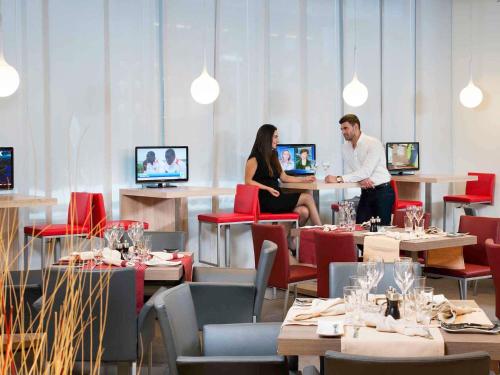 two people sitting at a table in a restaurant at Novotel Sofia in Sofia