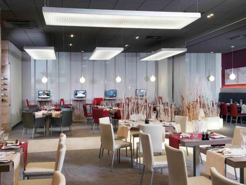 a dining room with tables and chairs and tablesktop at Novotel Sofia in Sofia