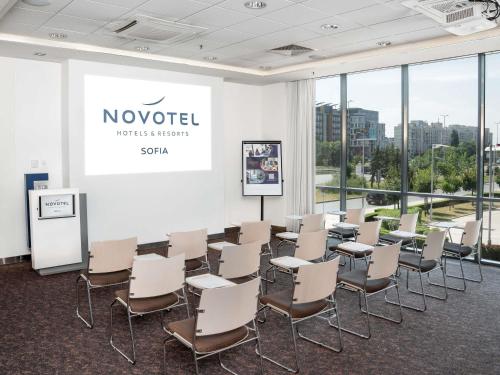 a conference room with chairs and a projection screen at Novotel Sofia in Sofia